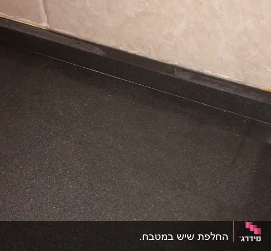 משטח שיש כהה ליד קיר בהיר